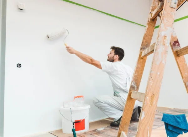 Artisan peintre au travail sur un chantier de peinture intérieure